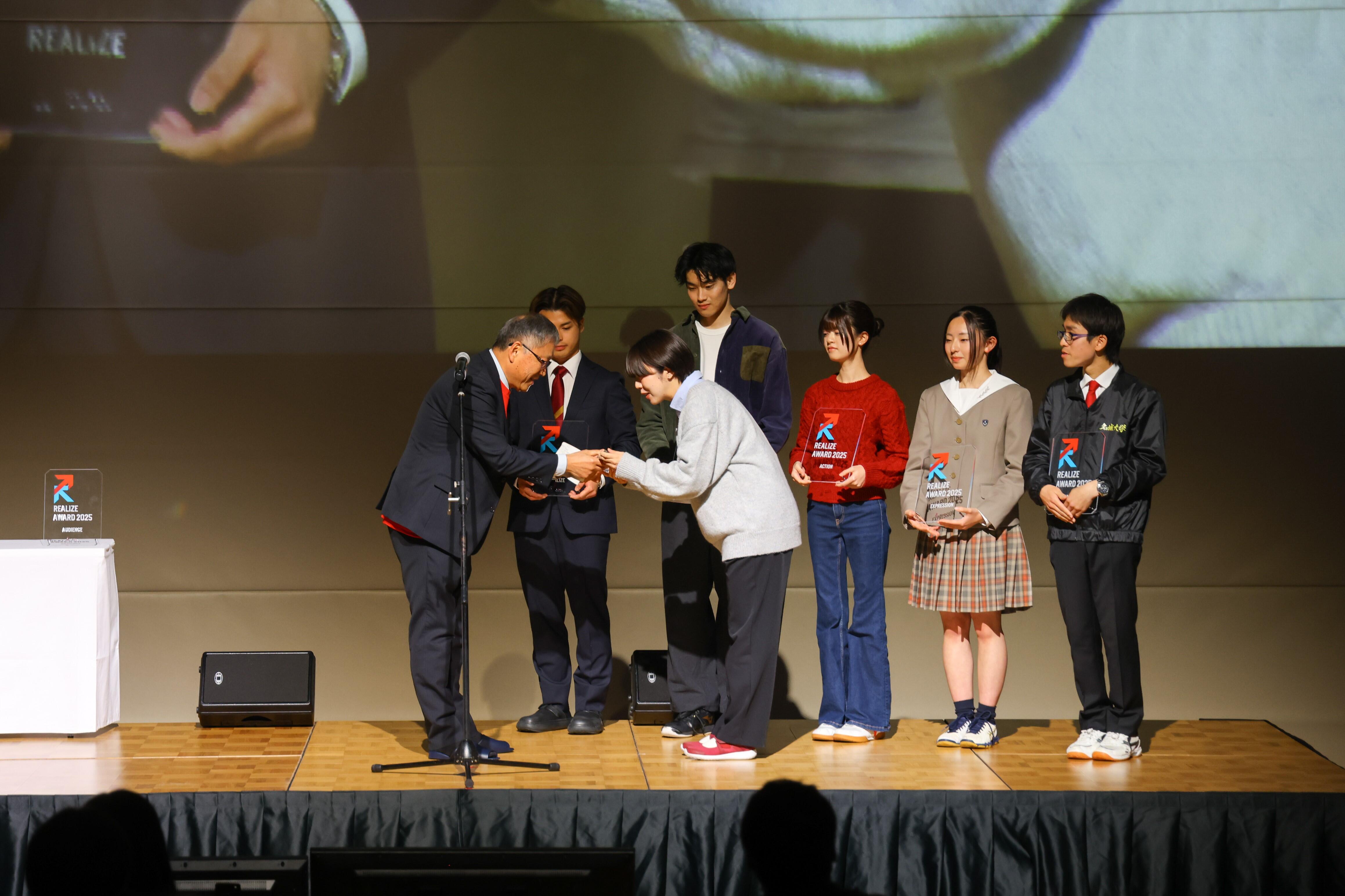 トロフィーを贈られる光岡さん