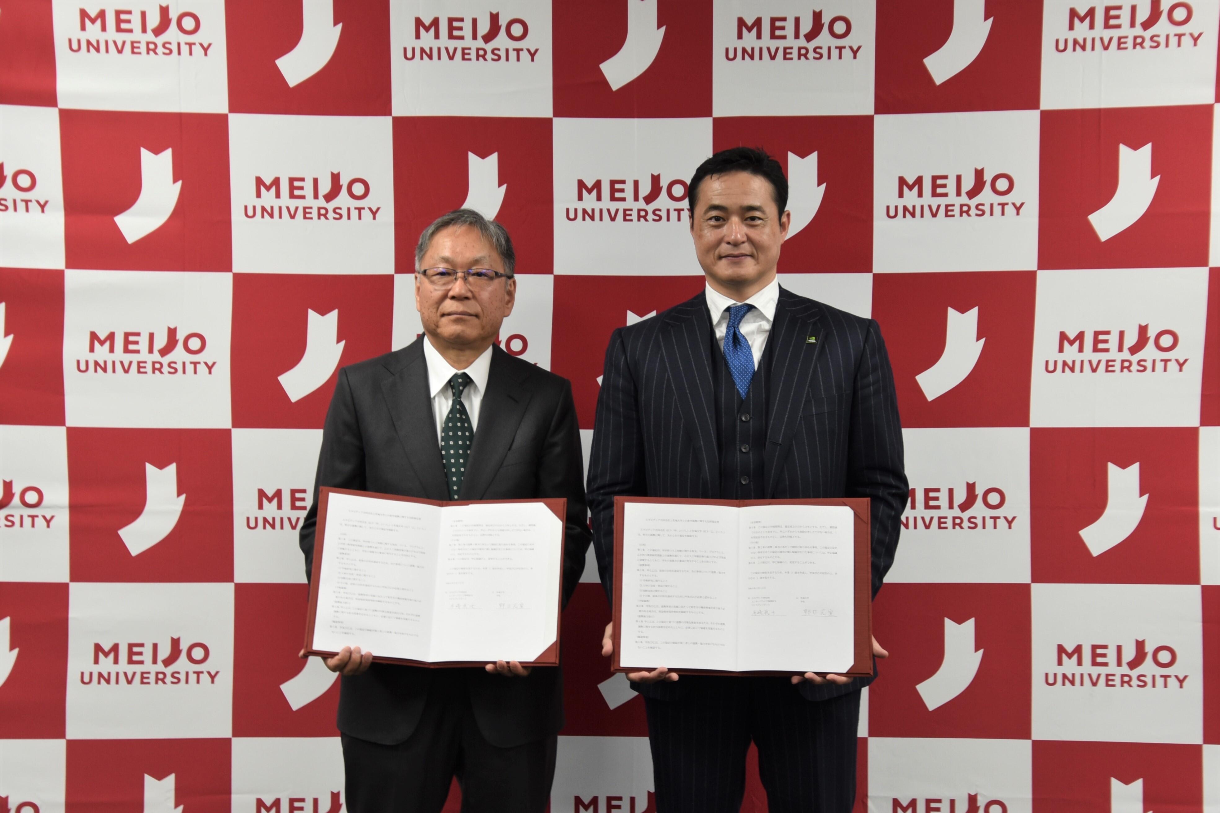 協定締結後、撮影に応じる野口学長（左）と井﨑バイスプレジデント