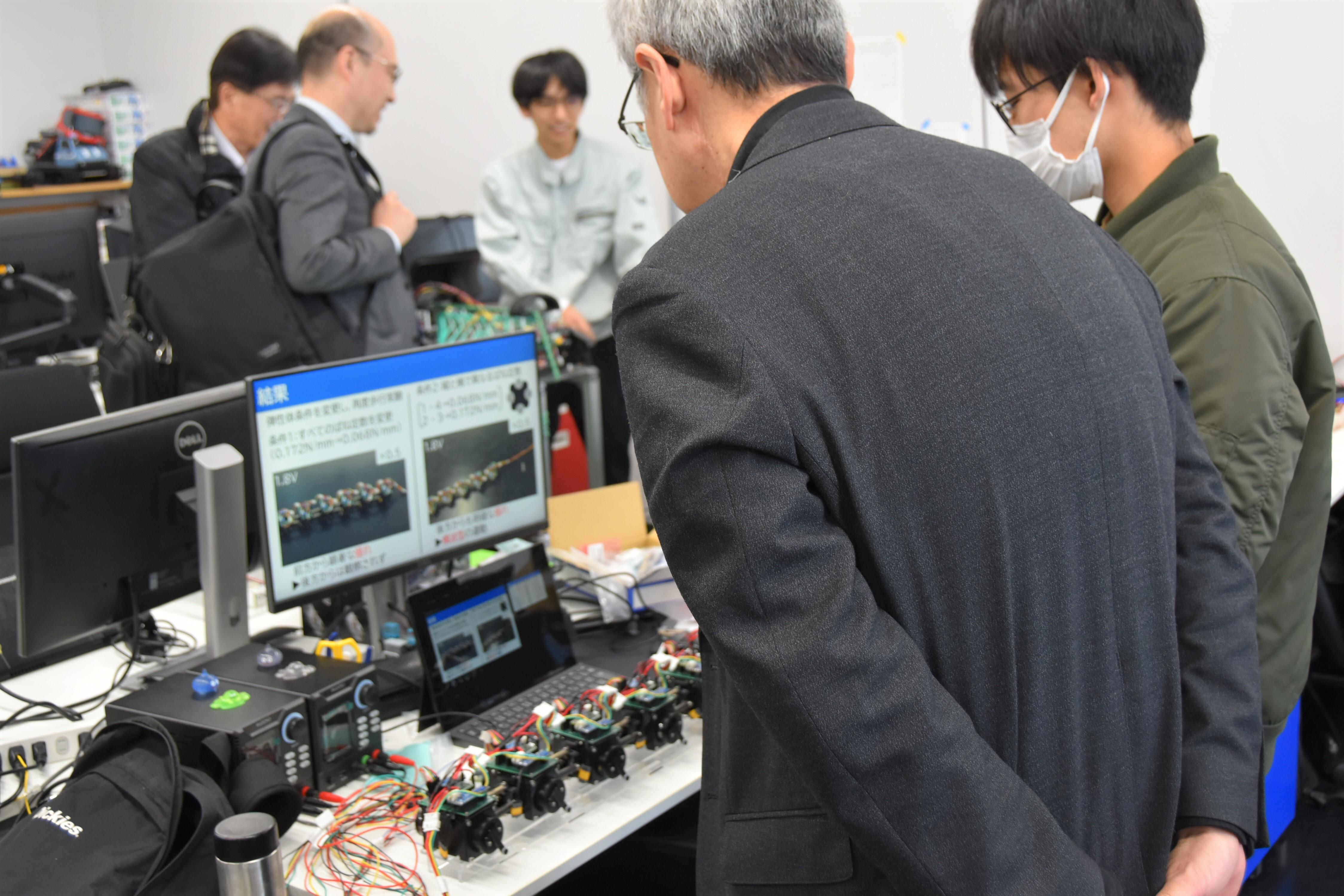 池本研究室の学生一人ひとりが実際のロボットを展示し、その動きを動画で説明