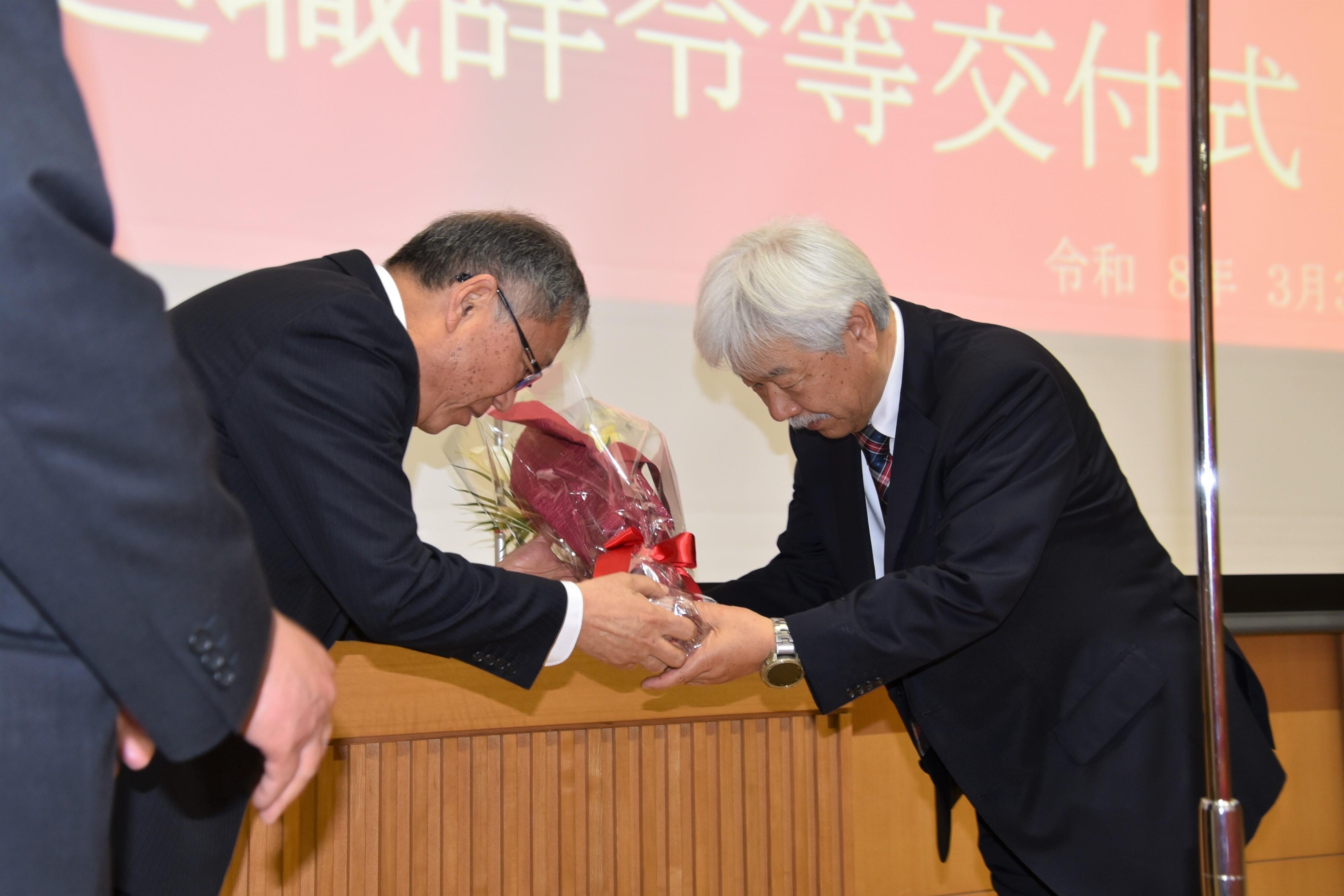 野口学長から花束を受け取る理工学部の服部友一教授