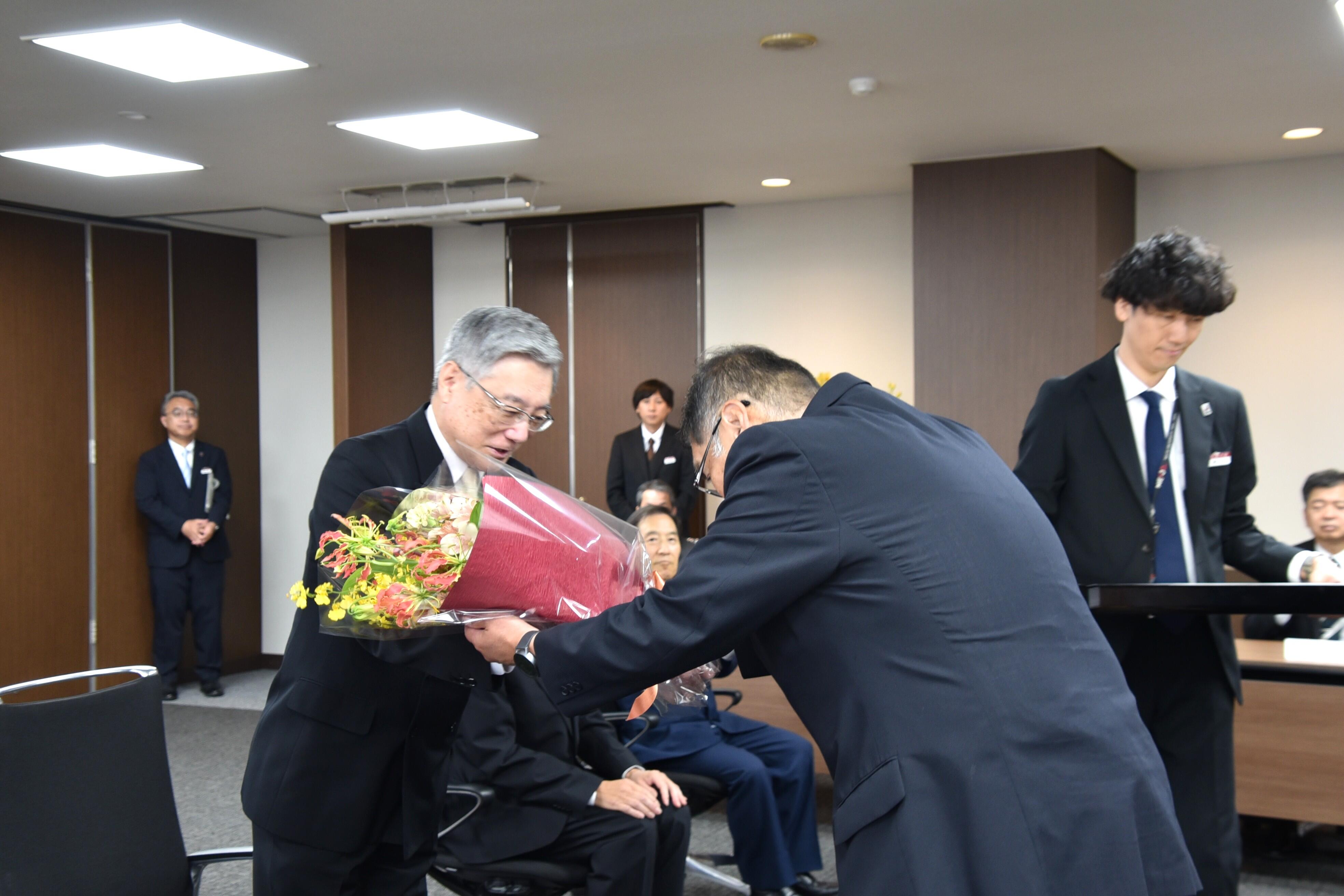 小原章裕理事長から花束を贈られる伊藤名誉教授