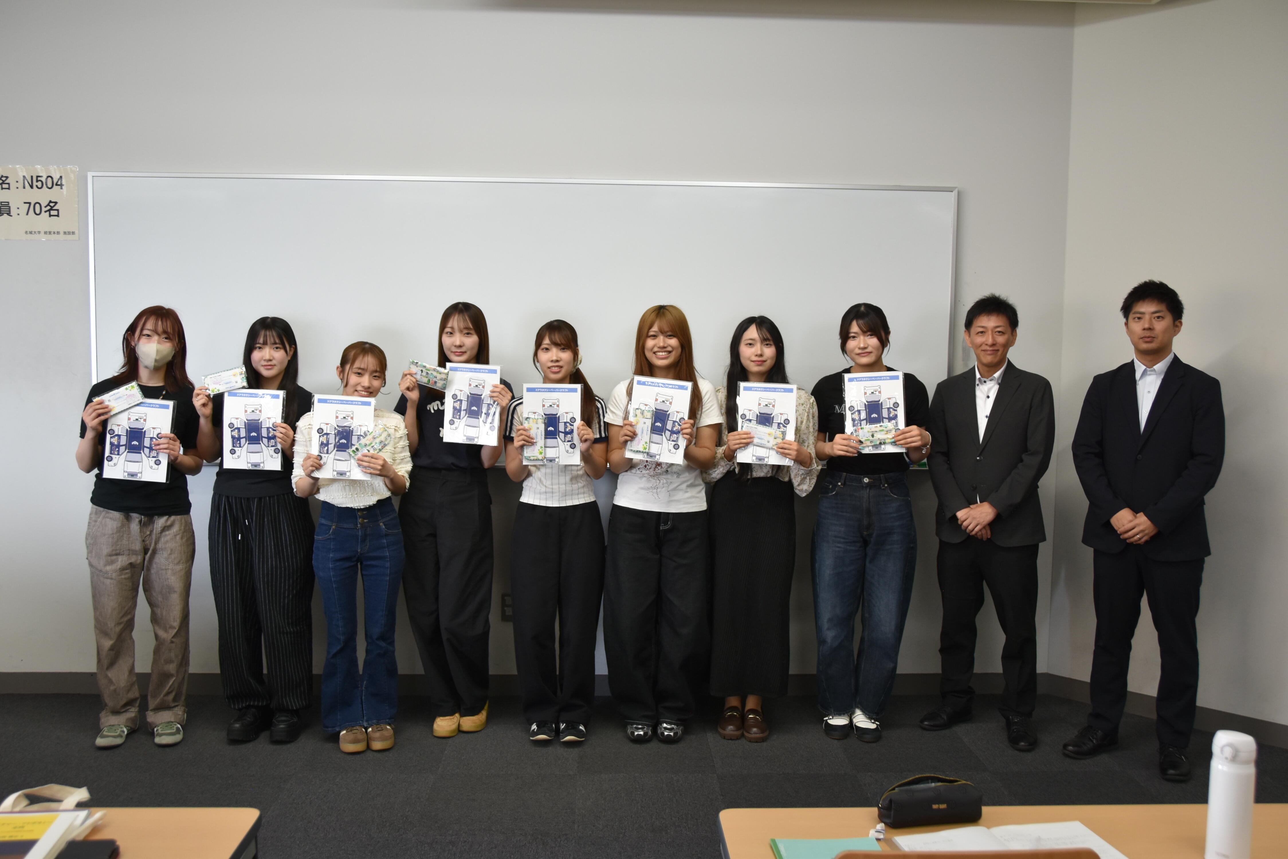 報告会で発表した8人の学生と名鉄タクシーホールディングスの山口部長と脇田課長補佐
