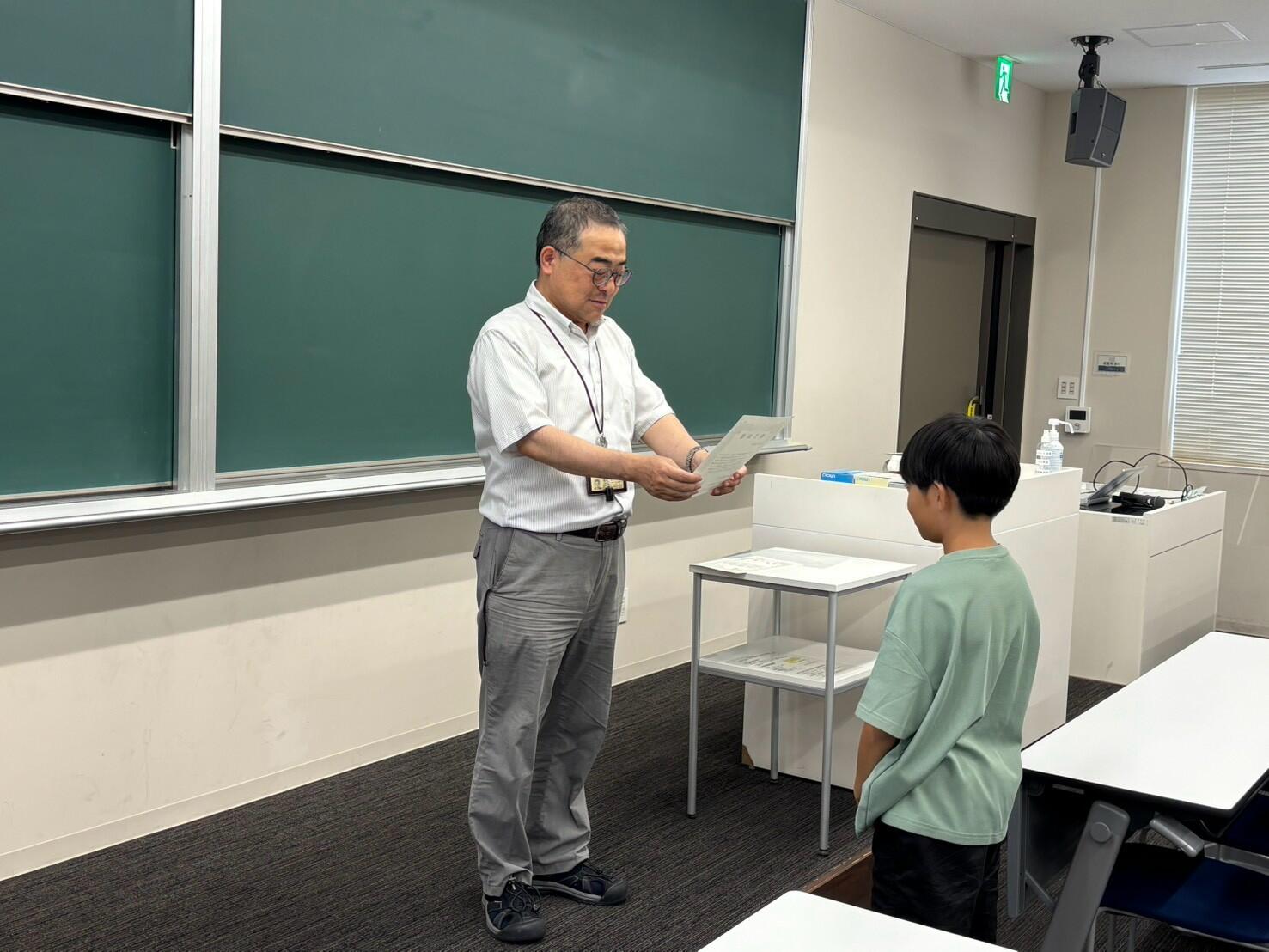 修了証を渡す間宮准教授