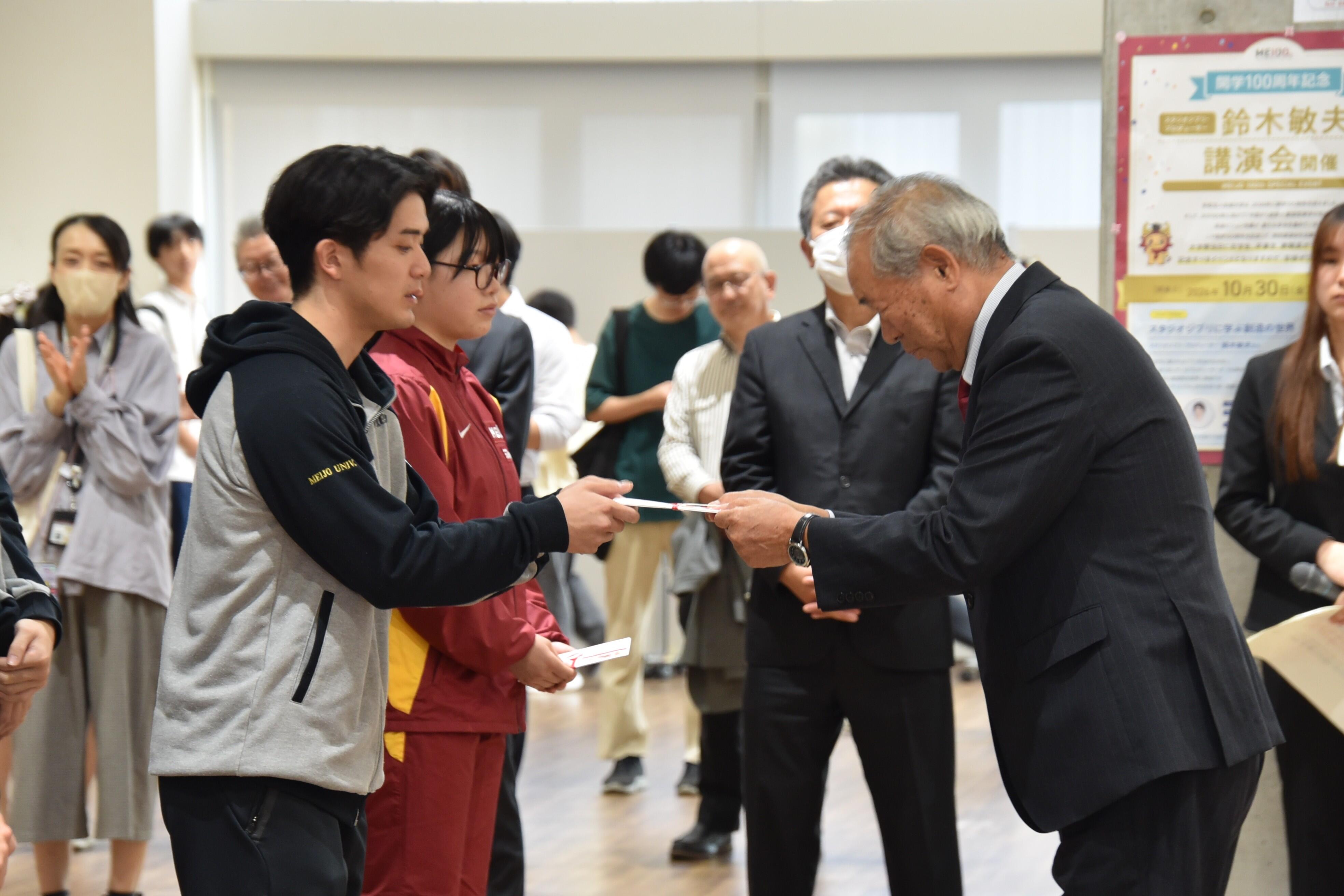 援助金を手渡すスポーツ・文化後援会の伊庭副会長（右）