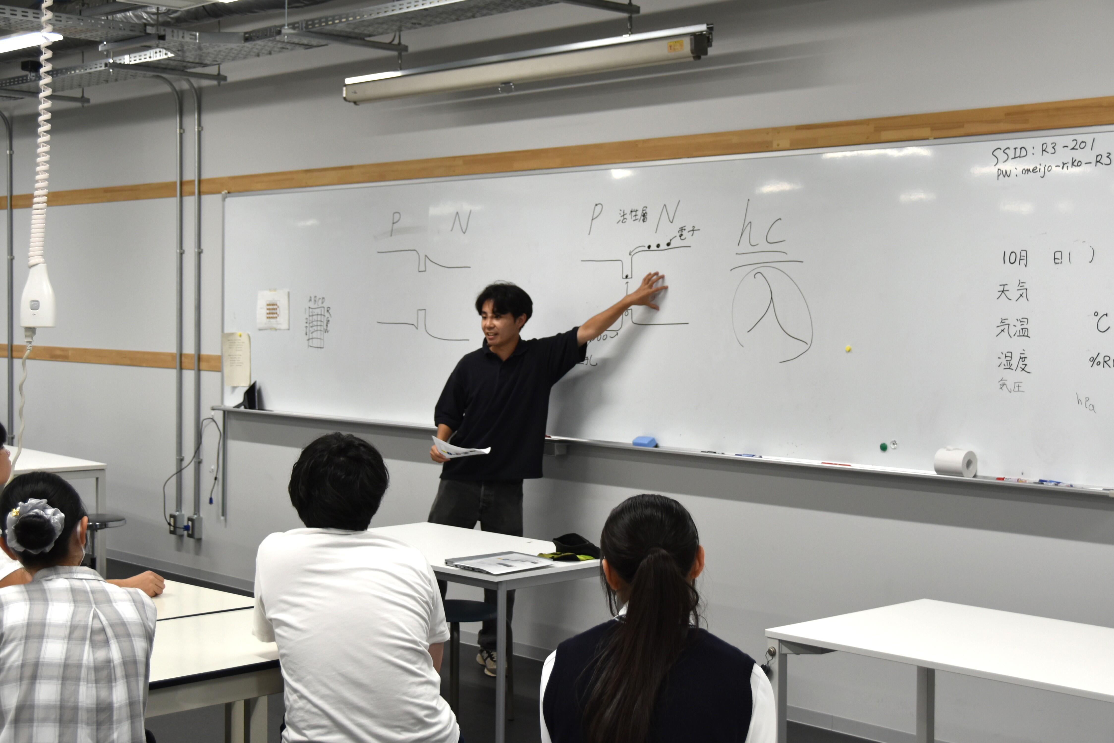 LEDの発光原理を説明する材料機能工学専攻の大学院生