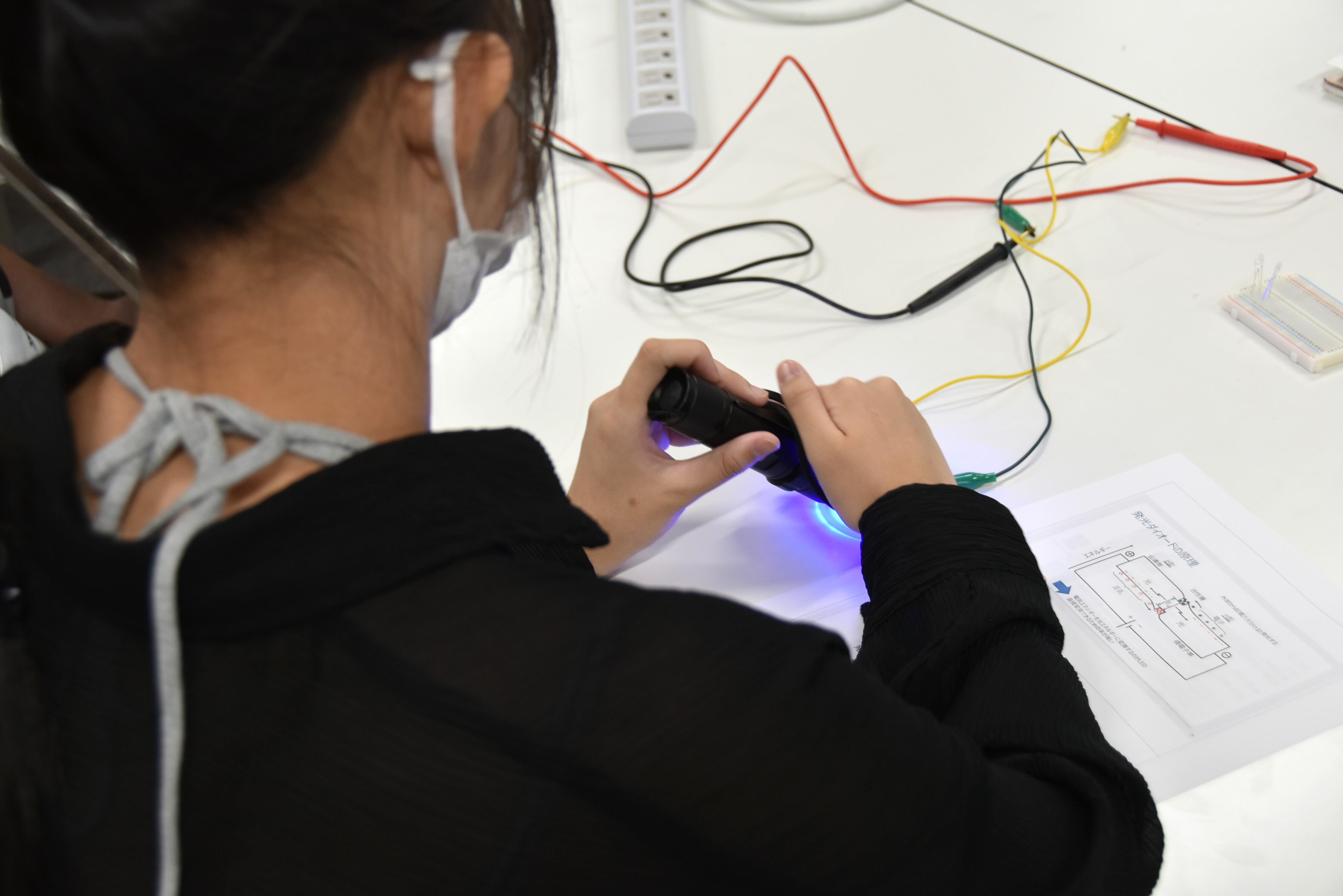 青色のLEDを照射して電気が流れることを測定する参加者
