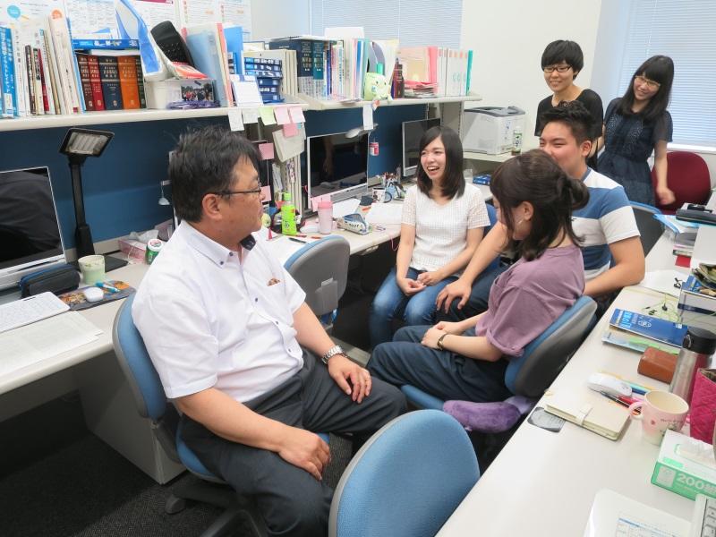 病院薬学研究室で学生と話す亀井教授（左端）