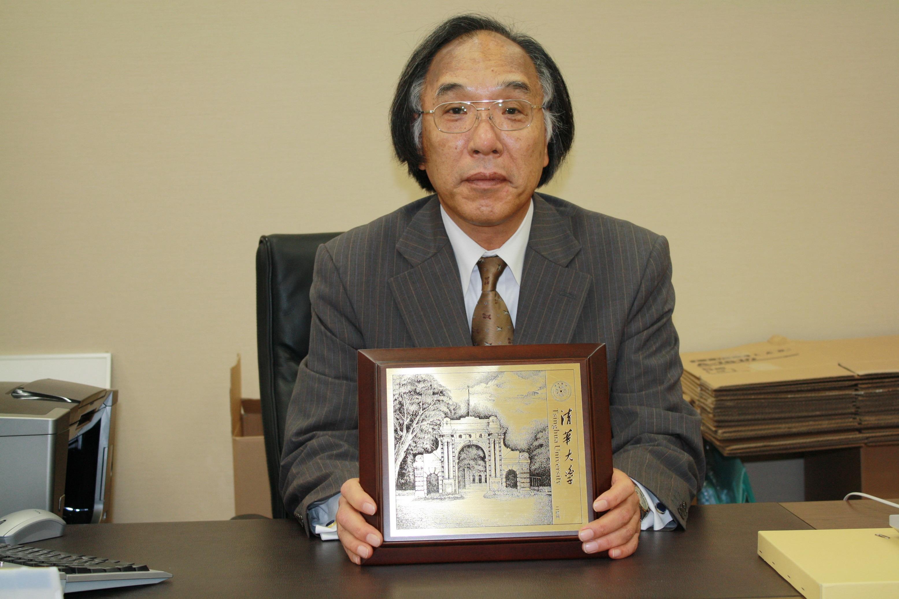 交流10周年で清華大学から贈られた記念品を手にする木村法学部長