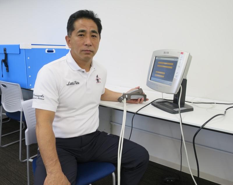 梅田教授と身体組成測定装置＝八事キャンパス新3号館で